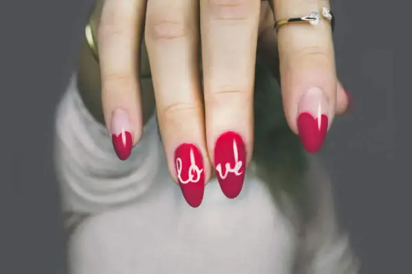 Unghie gel rosse con cuore e scritta "love". Perfetti disegni unghie gel facili per San Valentino.