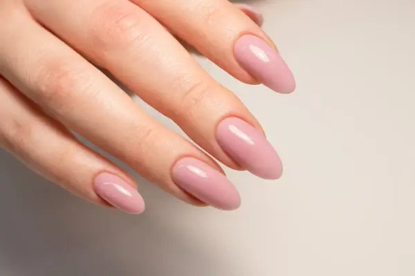 Mano con unghie naturali rosa pallido, forma a mandorla.